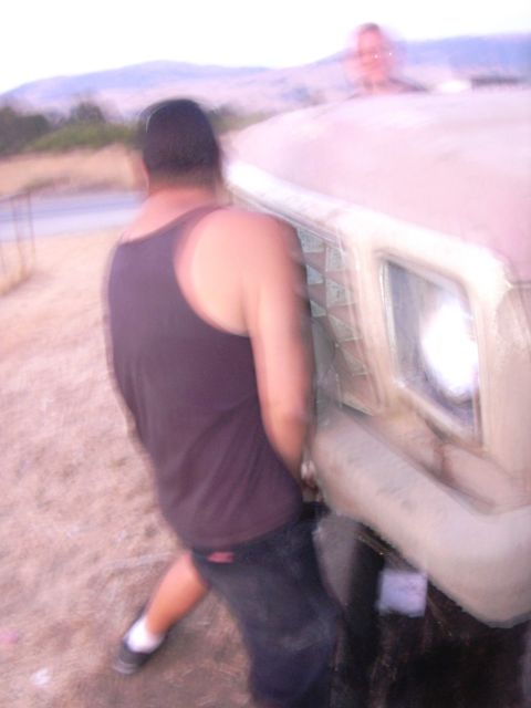 1978 Ford Bronco - A man leans against a truck in an outdoor setting with hills in the background.