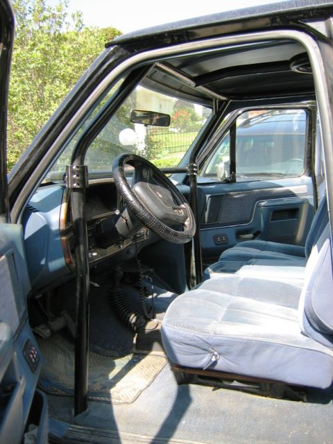 1985 Ford Bronco - Interior view of a 1985 Ford Bronco, a roll cage and blue upholstery.