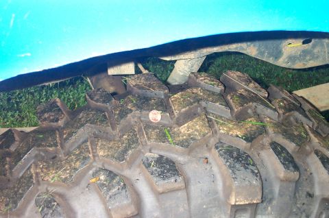 1987 Ford Bronco - Close-up of a tire tread with a coin for scale, suggesting off-road use.