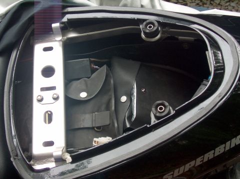 2002 Suzuki TL1000R - Open storage compartment in a motorcycle's tail section reveals a folded pouch and mounting hardware.
