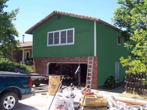1988 Ford Bronco - A blue pickup truck is parked in a driveway next to a house undergoing renovation.