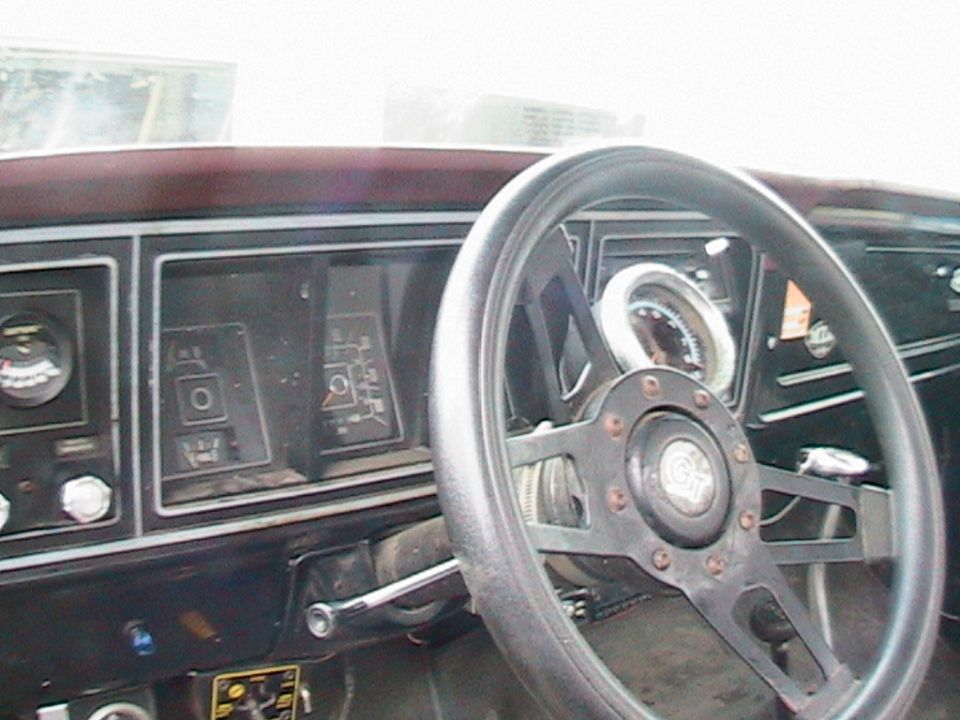 Dashboard of a 1977 Ford F-250 with a black steering wheel and gauges