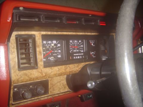 1986 Ford Bronco - Interior view of a vehicle's dashboard, analog gauges and wood-like trim.