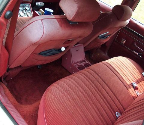 1985 Ford Crown Victoria LTD - The interior of a 1985 Ford Crown Victoria LTD features red velour seats and a center console with cup holders.