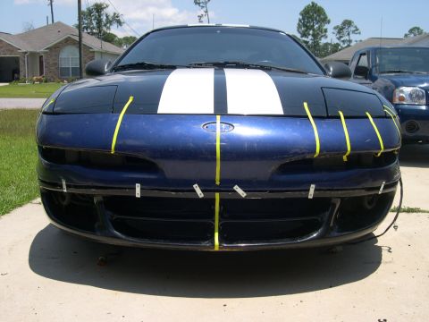 1997 Ford Probe - Front view of a blue 1997 Ford Probe with white racing stripes and yellow tape on the bumper.