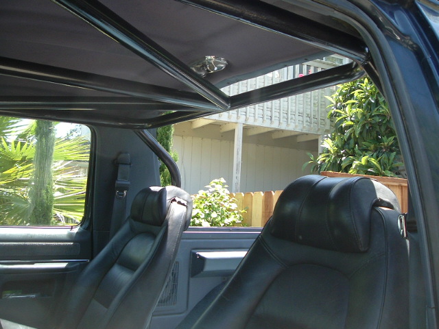 Interior of Ford Bronco showing black leather seats and removable hardtop roof
