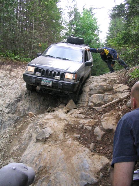 2000 Jeep Cherokee - Jeep Cherokee tackling a challenging off-road obstacle on a wooded trail.