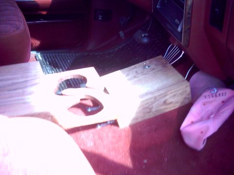 1990 Ford Bronco - Interior view of a 1990 Ford Bronco, showing custom wooden cup holder and red carpeting.