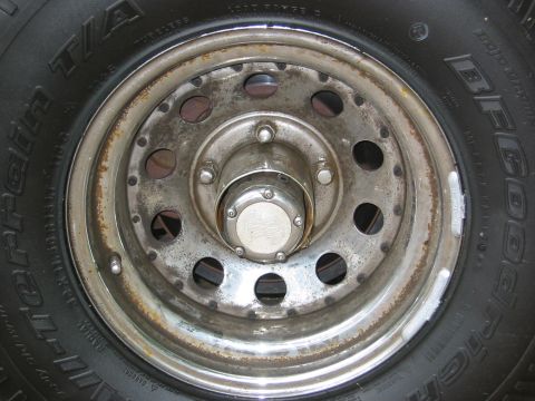 1990 Ford Bronco - A close-up view of a BFGoodrich tire and a weathered wheel, a chrome hubcap with visible lug nuts.