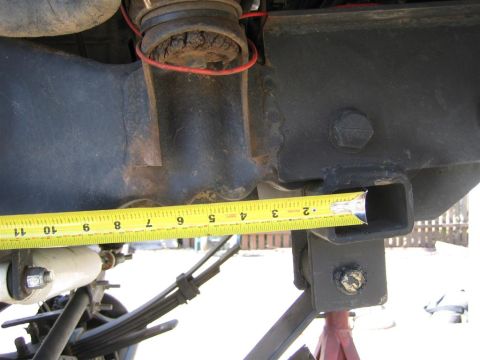 1994 Ford Bronco - Close-up of vehicle frame and suspension components with a measuring tape.