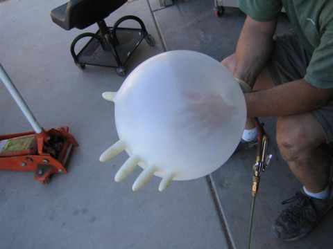 1994 Ford Bronco - A large latex glove is being inflated with a tool, with a car jack and stool visible in the background.