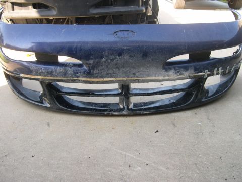 1997 Ford Probe - A blue car bumper with a damaged grille and visible tape is shown from the front.