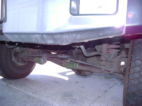 1991 Ford Bronco - Close-up view of the undercarriage of a vehicle, revealing suspension and steering mechanisms.