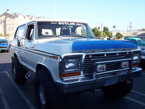 1995 Ford Bronco - This lifted Ford Bronco has a custom grille guard with KC lights and a blue cover on its hood.