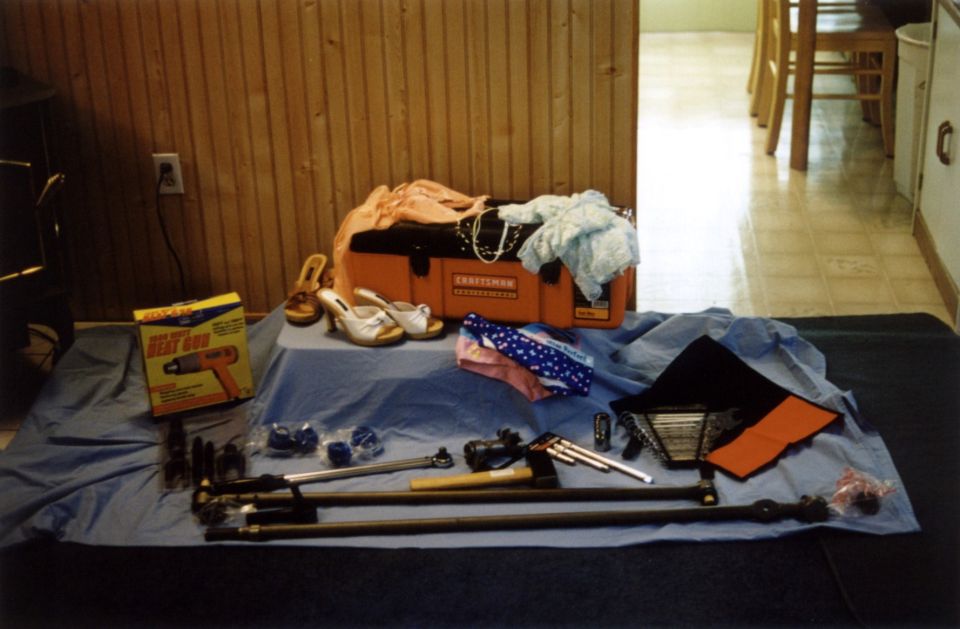 Craftsman toolbox, heat gun box, shoes, clothing, and various car parts laid out on a blue tarp