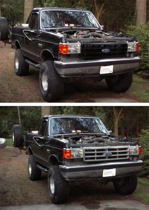 1988 Ford Bronco - Black Ford Bronco with hood open, front view, showing grille and spare tire on rear.