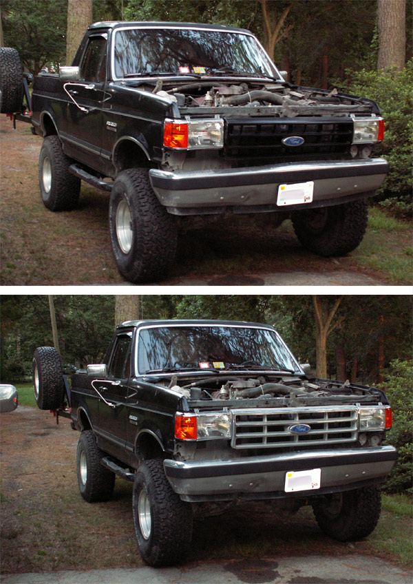 Black Ford Bronco with hood open, front view, showing grille and spare tire on rear
