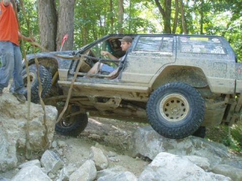 1992 Ford Bronco - An off-road SUV with a roll cage is shown navigating a rocky terrain.