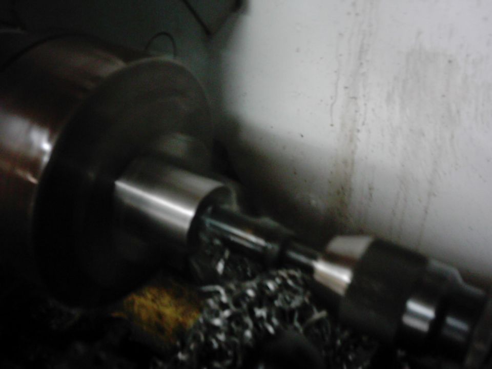 Machined metal shaft on a lathe with metal shavings