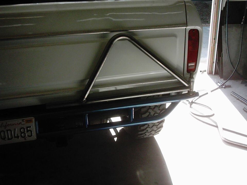 Rear of a truck with a custom bumper and a triangular spare tire carrier mounted. California license plate visible
