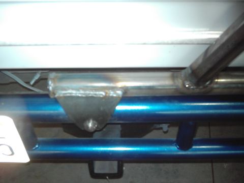 1978 Ford Bronco - Close-up of a custom-welded metal bracket attached to blue tubing, possibly part of a spare tire carrier system.