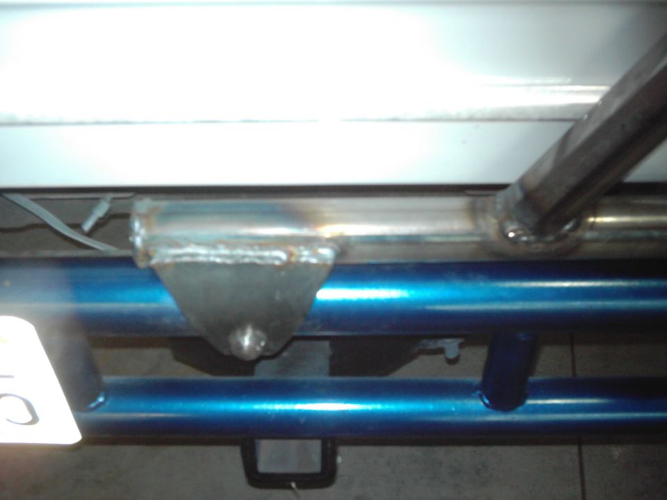 Custom metal mount welded to blue tubing, likely for a spare tire carrier