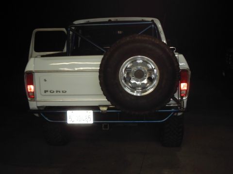 1978 Ford Bronco - Rear view of a white 1978 Ford Bronco, equipped with a spare tire carrier and an interior roll cage.