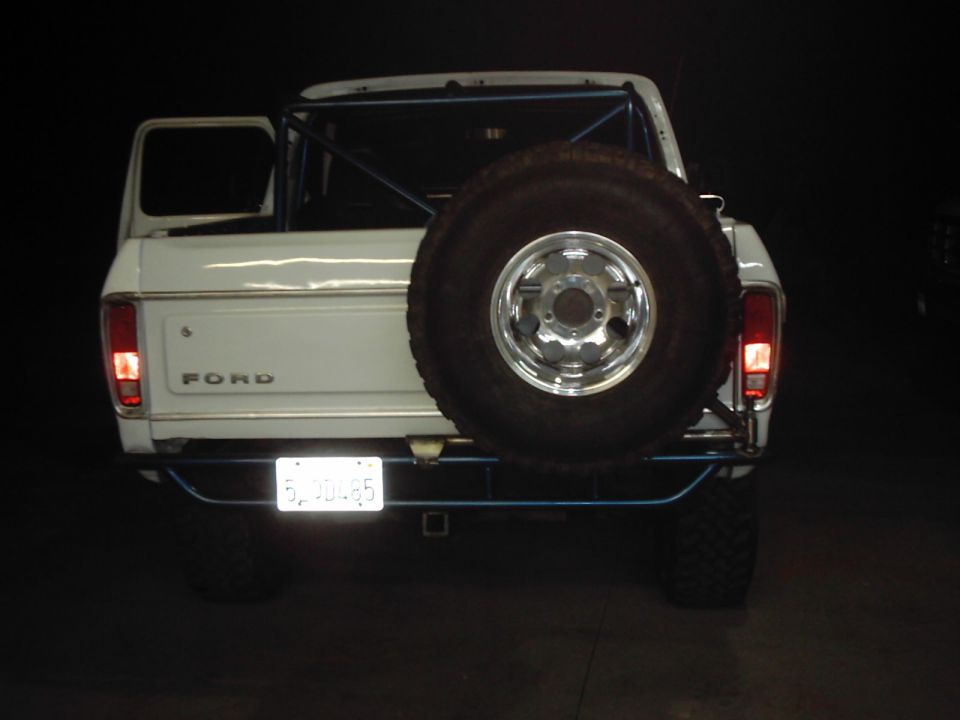 White 1978 Ford Bronco rear view with spare tire carrier and roll cage