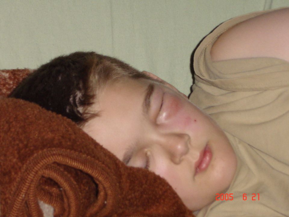 Child sleeping on a brown blanket