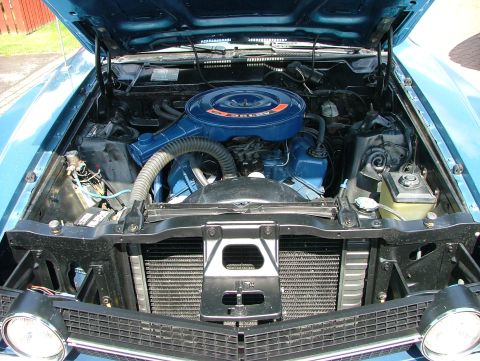 1970 Ford Ranchero - The engine bay of a blue Ford pickup truck, a V8 engine and air cleaner assembly.