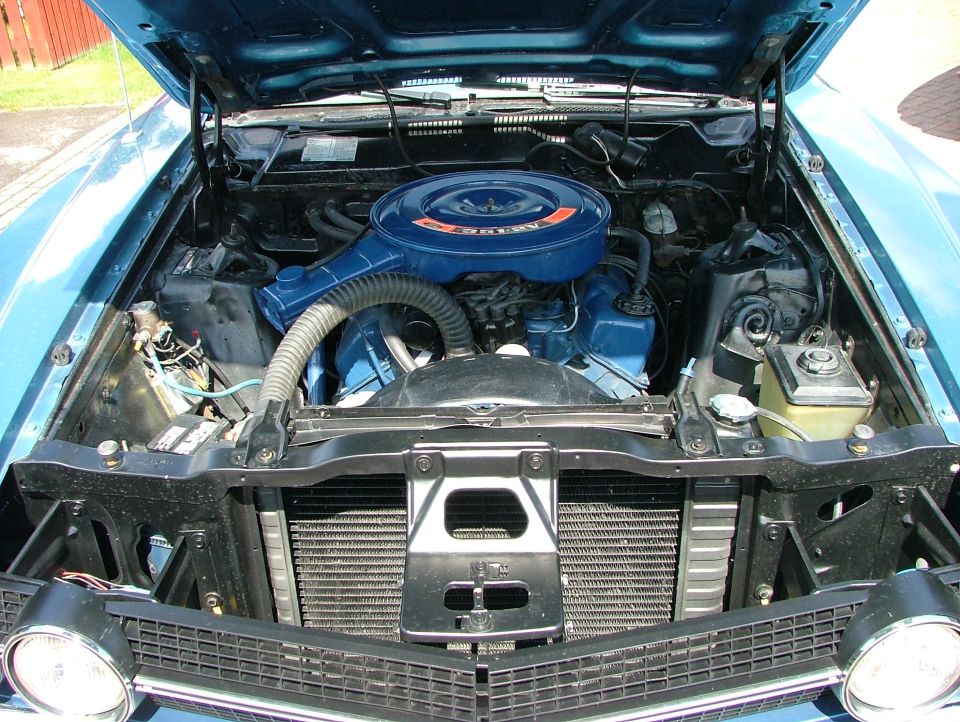 Blue Ford pickup truck engine bay with V8 engine and air cleaner