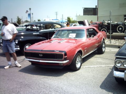 1995 Ford Probe - A red 1967 Chevrolet Camaro SS is parked at an outdoor car show.