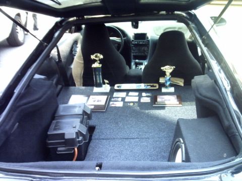 1995 Ford Probe - Trophies and car audio equipment are displayed in the trunk of a car.