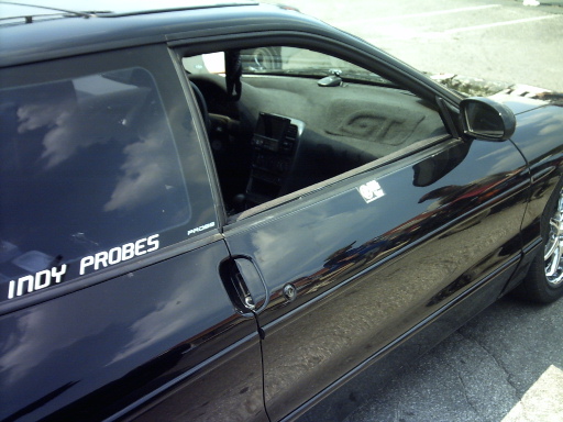Black 1995 Ford Probe interior with 'INDY PROBES' sticker on the driver's side window