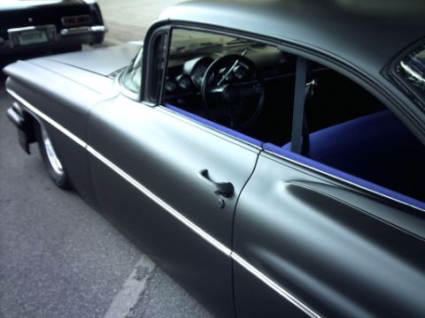 1995 Ford Probe - A matte gray classic car is parked next to another vehicle, with a view of its interior.