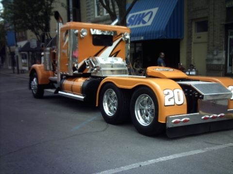 1995 Ford Probe - An orange semi-truck with chrome detailing and the number 20 is parked on a street.