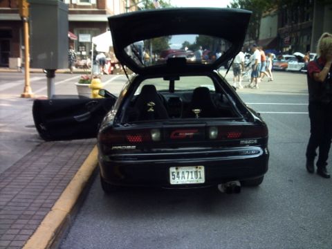 1995 Ford Probe - A black Mazda MX-6 is parked on the street with its trunk and driver's door open, showing its interior.