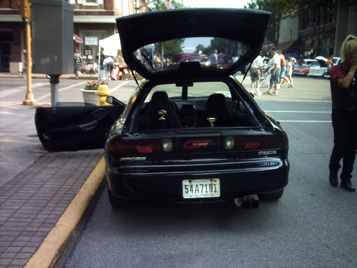 black Mazda MX-6 with trunk and driver door open, parked on street