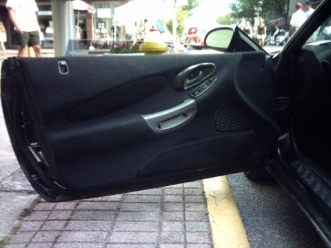 1995 Ford Probe - Interior of a black car door, showing the fabric paneling and controls.