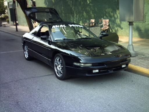 Black 1995 Ford Probe with trunk open, parked on a street