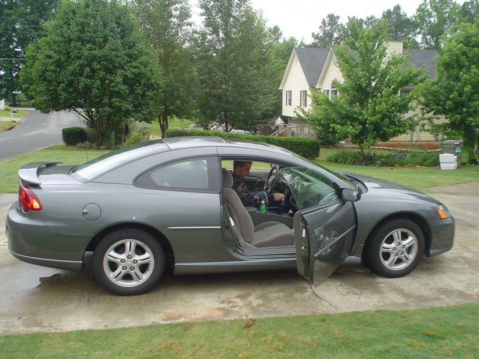 Gray coupe, driver's door open, side view