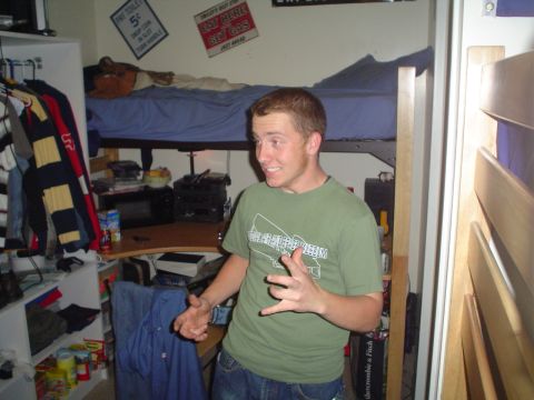 1981 Ford Bronco - A young man stands in a cluttered dorm room, with a bunk bed above a desk.