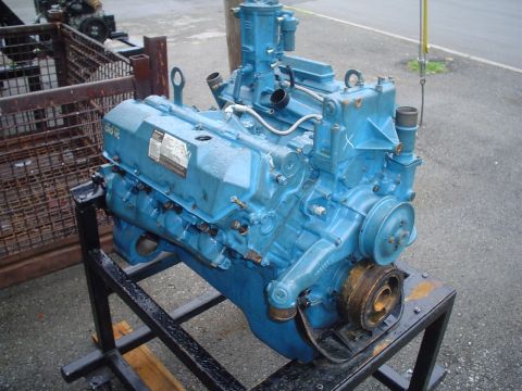 1981 Ford Bronco - A blue engine, likely a V8, is mounted on a metal stand outdoors.