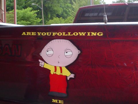 1981 Ford Bronco - A truck bed displays a sticker of Stewie Griffin from Family Guy, with text asking 'ARE YOU FOLLOWING ME'.