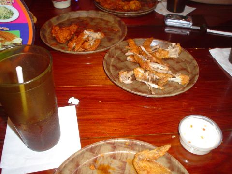 1981 Ford Bronco - The remnants of a meal, including fried chicken bones and a beverage, are visible on a wooden table.