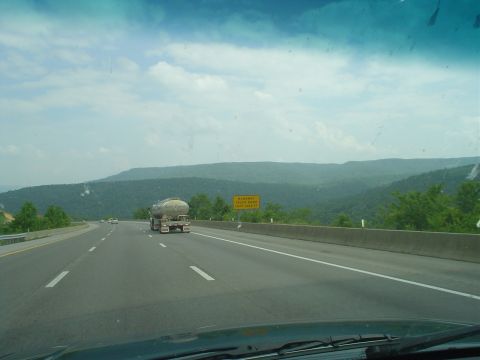 1981 Ford Bronco - Driving on a highway with a tanker truck in the distance and a mountainous landscape.