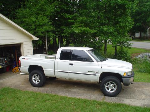 1981 Ford Bronco - A white pickup truck is parked in a driveway next to a garage.