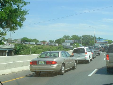 1981 Ford Bronco - A highway scene shows a traffic jam with various vehicles on a sunny day.