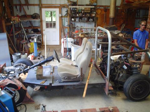 1981 Ford Bronco - A partially assembled vehicle sits in a cluttered garage with tools and equipment visible.