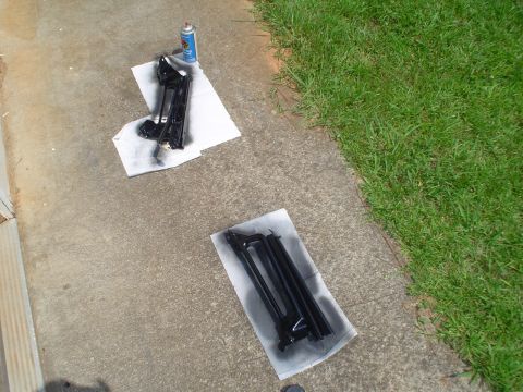 1981 Ford Bronco - Two automotive parts are drying on paper towels after being spray painted black.